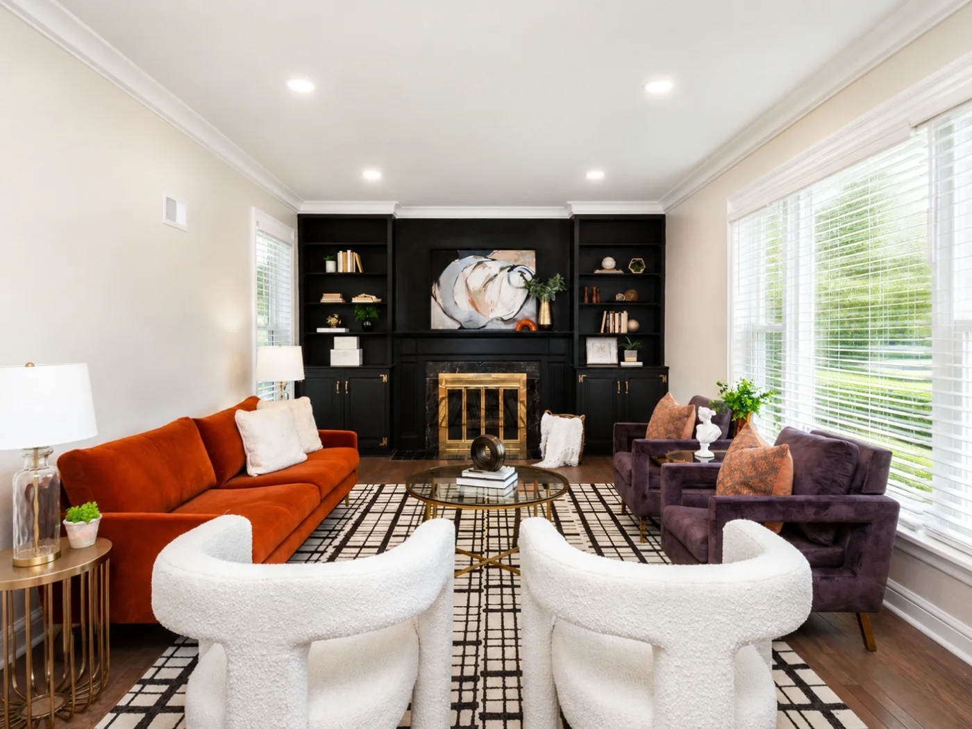 Living room with custom built-in shelving, fireplace, and bold decor